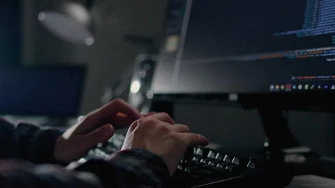 A professional programmer works remotely in a home office, writes code to cr Stock Footage 245427264