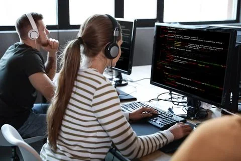 Professional programmers working with computers in office Stock-Fotos