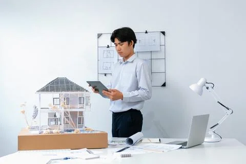 Professional project manager using tablet to check house model. Immaculate. 写真素材