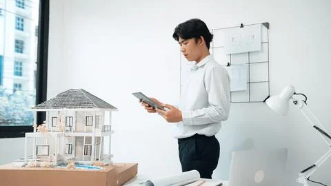 Professional project manager using tablet to check house model. Immaculate. 写真素材