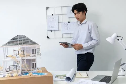 Professional project manager using tablet to check house model. Immaculate. Stock Photos