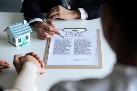 Professional real estate agent explaining the document process to the customer Stockfoto's