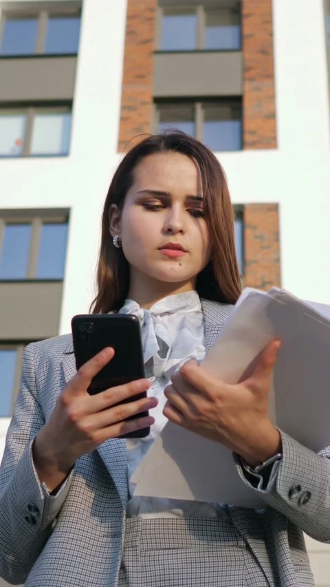 Professional real estate agent using smartphone app for property management with Stock Footage 341444907
