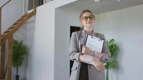 Professional Realtor Standing in Bright Two-Level Flat Holding Documents Stock-Footage 311853773