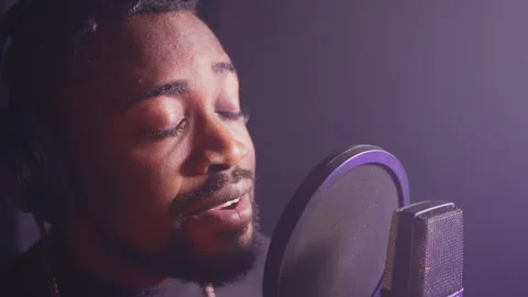 Professional recording studio, black man is singing romantic song to microphone 스톡 동영상 241827873