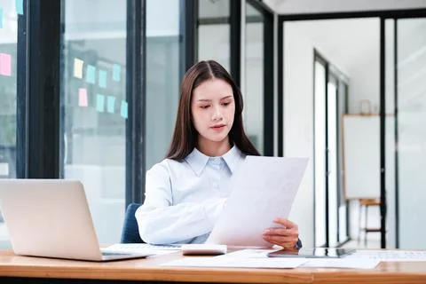 Professional reviewing documents and analyzing data in a modern office Stock Photos