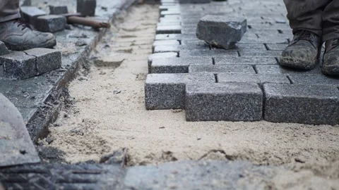 Professional road construction workers paving street with stone bricks onto.. Stock-Footage 332745607