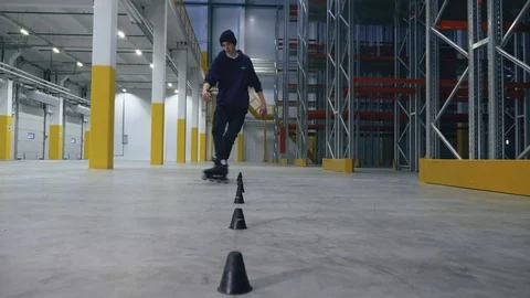 Professional rollerskater doing slalom in the logistics center slowmotion Video stock 104361621