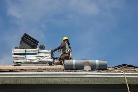 Professional Roofer in Hard Hat Installing Asphalt Shingles on Residential .. Stock-Fotos