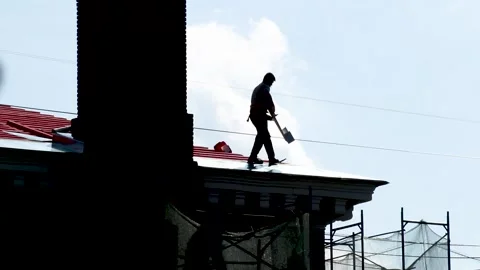 Professional roofer working on red metal roof. Russia - 04 September 2026 Stock Footage 341833535