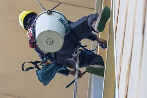 Professional rope access window cleaner working at height on building exter.. Stock Photos