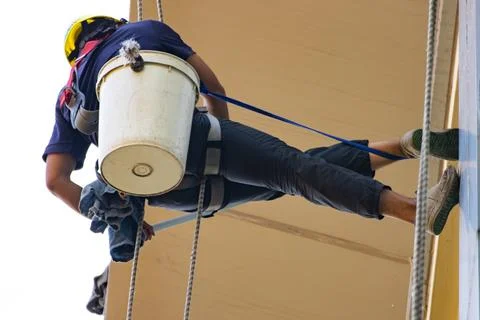 Professional rope access window cleaner working at height on building exter.. 库存照片