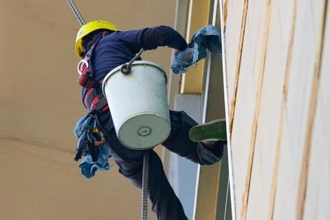 Professional rope access window cleaner working at height on building exter.. 库存照片