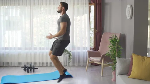 Professional runner doing cardio training at home by running on the spot wearing Stock Footage 219727501