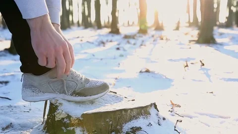 Professional runner preparing for training. Tying shoelaces sneaker. Listening Stock Footage 77035986