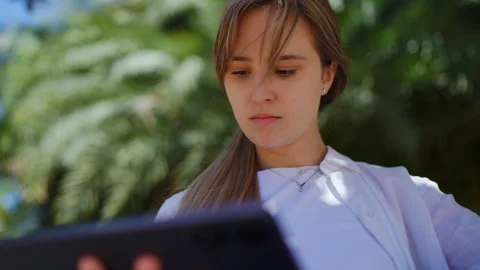 Professional scientist analyzing research data on tablet, sitting amid verdant Video stock 308389286