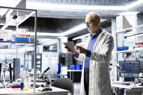 Professional scientist analyzing samples in modern laboratory setting 스톡 사진