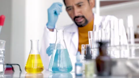 Professional scientist with beard drop liquid blue and yellow solution, tea.. Stock Footage 243413621