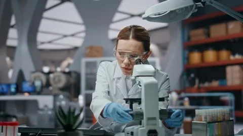 Professional scientist looking microscope analyzing sample closeup. Woman doctor Foto stock