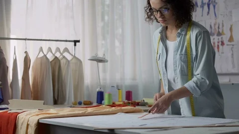 Professional seamstress marking patterns, considering dimensions of customer Stock Footage 84952354