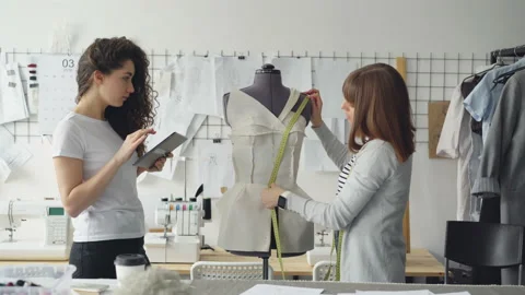 Professional seamstress is measuring patterns on mannequin with measure-tape Stock Footage 88943761