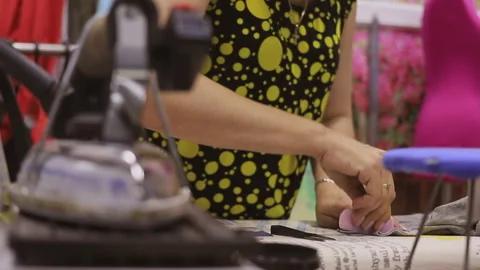 A professional seamstress at work in his workshop. She crafts her work with 库存影片 133076637
