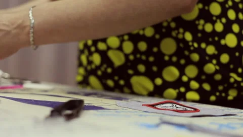 A professional seamstress at work in his workshop. She crafts her work with Stock Footage 133076753