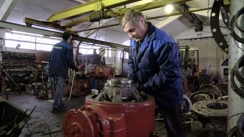 Professional senior mechanic repairs the rear axle of a dump truck. Heavy Stock Footage 75140553