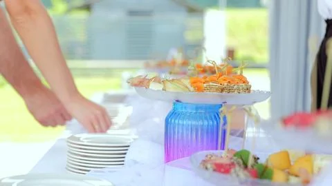 Professional server preparing gourmet appetizers, arranging canapes, fruit Stock Photos
