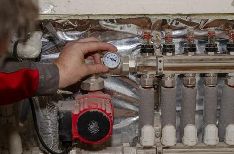 Professional service of heating systems concept. Specialist makes adjustments Stock Photos