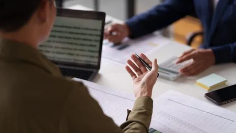 Professional setting featuring two individuals working at a table. They are.. Foto stock