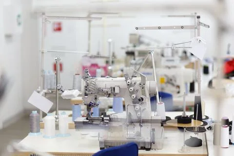 Professional sewing machine with thread in workshop. Stock Photos