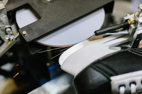 Professional sharpening machine grinding the metal blade of a black ice hockey Stock Photos
