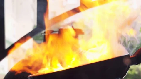 Professional shef in black gloves cooking with flame in a frying pan Stock Footage 101915364
