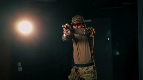 At a professional shooting range a military trainer reloading a pistol ready to Stock Footage 277172436