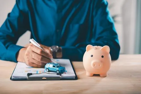 Professional signs car finance documents with piggy bank money and auto ins.. Stock Photos
