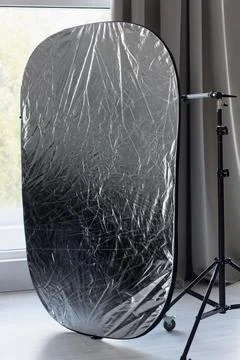 Professional silver reflector mounted on stand in a photo studio Stock Photos
