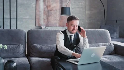 A professional sits in a beautiful dark office in front of a laptop. The Stock Footage 196822975
