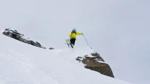 Professional skier jumping and making turns while skiing downhill Stock Footage 116740433