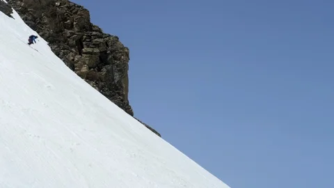 Professional skier making turns while skiing down steep snowy mountain slope Stock Footage 116744553
