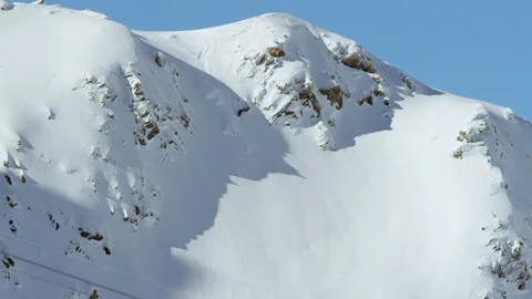 Professional skier skiing down the slope while ski lift moving in foreground Stock Footage 116740968