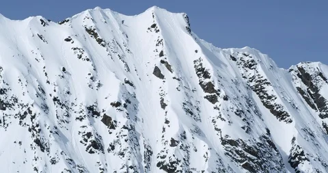 Professional skier skiing down a steep cliff face Stock Footage 111998835