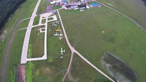 Professional skydiver fly down on parachute in air above green field. Height Stock Footage 70532533
