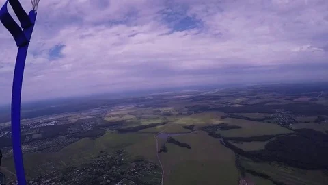 Professional skydiver on parachute fly down to green field. Extreme sport Stock Footage 70532572