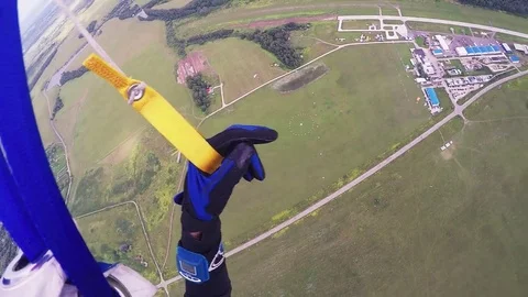 Professional skydiver on parachute fly over green field, forest. Extreme sport Stock Footage 70532467