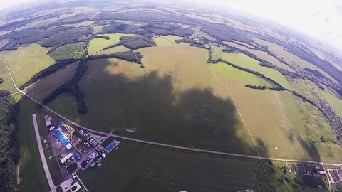 Professional skydiver parachuting, calm flight over green field in sunny day Видео 70533191