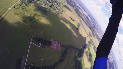 Professional skydiver parachuting, fly above green field in sunny day. Landscape Stock Footage 70532934