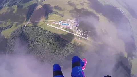 Professional skydiver parachuting, fly over green field in cloudy day. Sunny Stock Footage 70533081