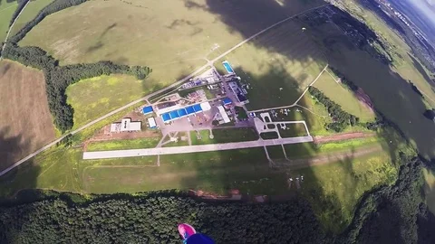 Professional skydiver parachuting, fly over green forest. Landscape. Sunny Stockbeeldmateriaal 70533083