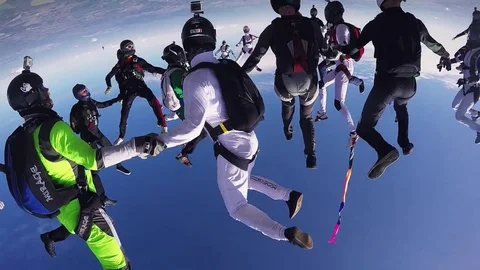 Professional skydivers make big formation in blue sky. Open parachute. Teamwork Stock Footage 70532604